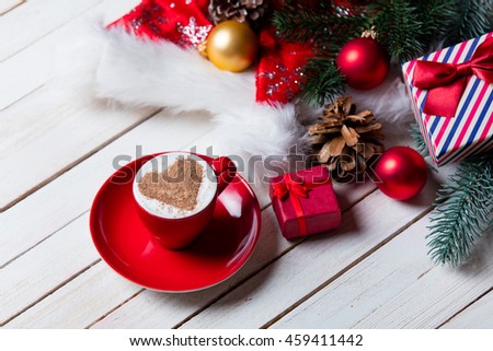 photo of the cup of coffee and christmas decorations on the white wooden background