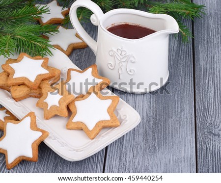  Christmas gingersnap and hot chocolate in a small jug on a gray wooden background. A Christmas background with space for the text.