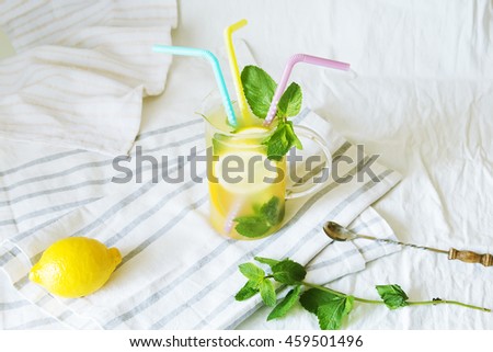 Lemonade with ginger and mint in kitchen. Summer drinks. Home made ginger lemonade on striped napkin or towel. Healthy drink lemonade.