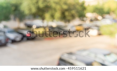 Abstract blurred elevated view of apartment garage with full of covered parking, cars and green trees at multi-floor residential buildings in Houston, Texas, US. Aerial view crowded parking. Panorama.