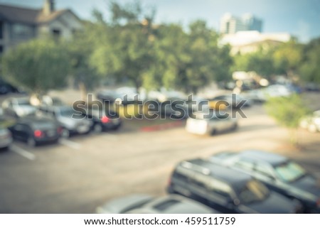 Abstract blurred elevated view of apartment garage with full of covered parking, cars and green trees at multi-floor residential buildings in Houston, Texas. Aerial view crowded parking. Vintage look.