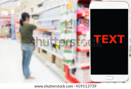 Girl use mobile phone, blur image of inside supermarket as background.