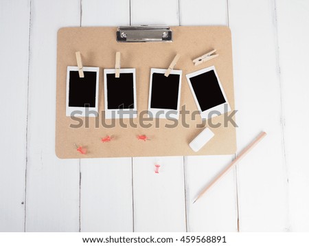 Blank photos on a board with white wood background.