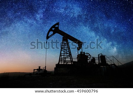 Silhouette of oil pump in the oil field in the night under Milky way