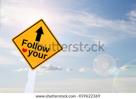Text for Follow your hart on yellow road sign with blur blue sky background