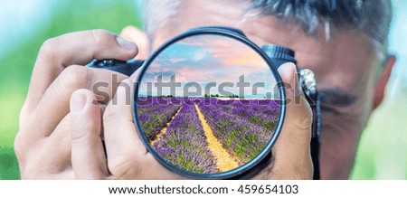 Photographer taking photo with DSLR camera at lavender fields. Shallow DOF..