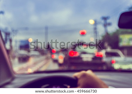 vintage tone blur image of people driving car on day time for background usage.(take photo from inside)