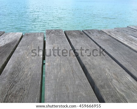Wooden table on sunny day near sea.View from the pier on the sea at loneliness beach Royalty-Free Stock Photo #459666955