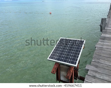 solar cell Wooden table on sunny day near sea.View from the pier on the sea at loneliness beach Royalty-Free Stock Photo #459667411