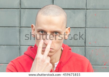 Street bully in a red hoodie shows that watching you