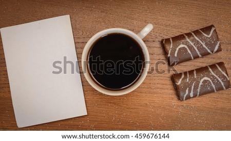 Blank paper and black coffee cup on wood table