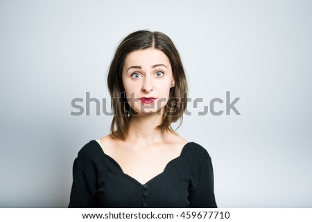 young woman shocked, studio photo isolated on a gray background