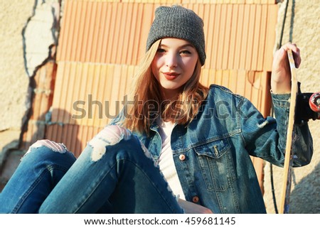 Beautiful young woman with skateboard Fashion style Urban background