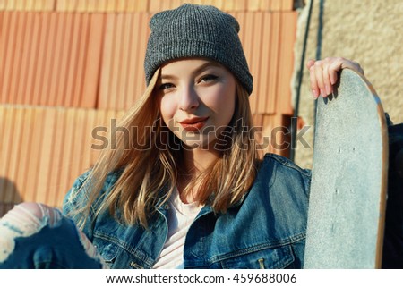 Beautiful young woman with skateboard Fashion style Urban background