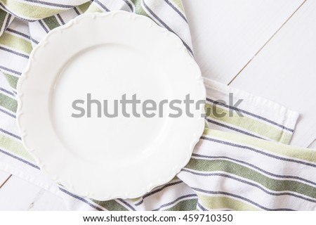 Empty white ceramic dish on a wooden table. View from above
