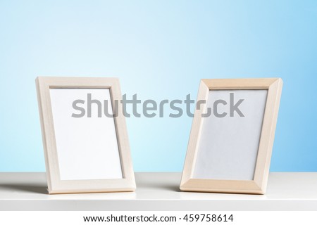 2 blank white picture frames on the table wood