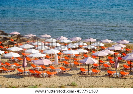Beach umbrella and sun chairs on the sandy beach in Greece