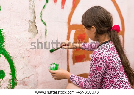 Children drawing on the wall depict the house in the summer outdoors