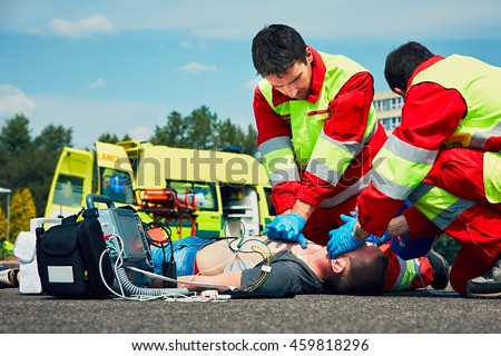 Cardiopulmonary resuscitation. Rescue team (doctor and a paramedic) resuscitating the man on the street.   Royalty-Free Stock Photo #459818296