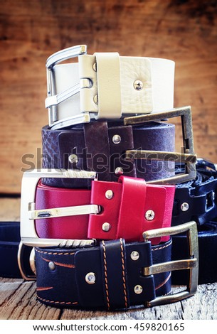 Stack of  belts, vintage wooden background, selective focus