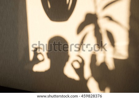 Man showing gesture by his shadow on the wall
