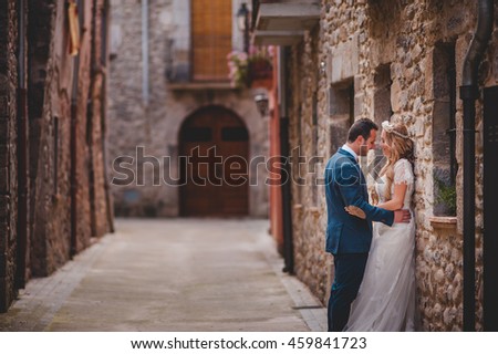 charming bride and her husband standing  on the street