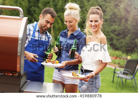 Picture presenting group of friends having barbecue party