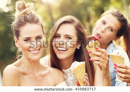 Picture presenting happy group of friends eating ice-cream outdoors