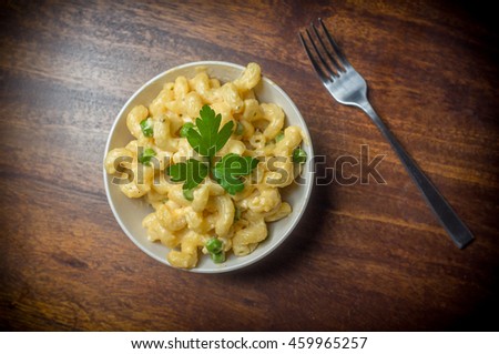 Delicious macaroni and cheddar cheese with parsley sprig Royalty-Free Stock Photo #459965257