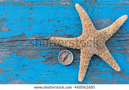 Starfish, compass and a sun hat on an old blue wooden background, the concept of travel, vacation, journey