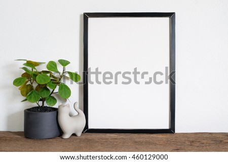 mock up of blank photo frame with plant pot on wooden shelf.
