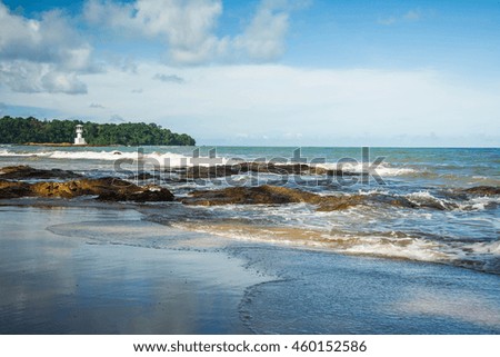 Sea waves crashing over rocks on wild stone beach 
