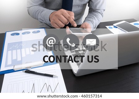 CONTACT US (Customer Support Hotline people CONNECT ) Businessman working at office desk hands top view with laptop and financial reports and using a  smart phone