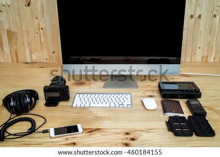Office computer PC camera, mobile phone, headphone,sound recorder,passport,memory card,keyboard and mouse on wooden desk