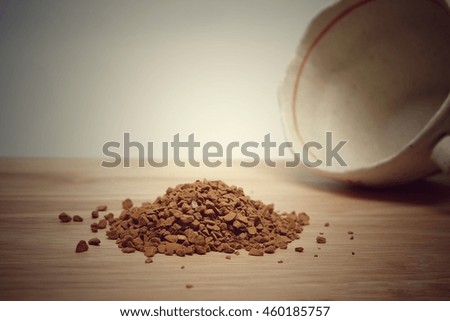 Vintage tone brown powders of coffee with blur glass of coffee and blur background.