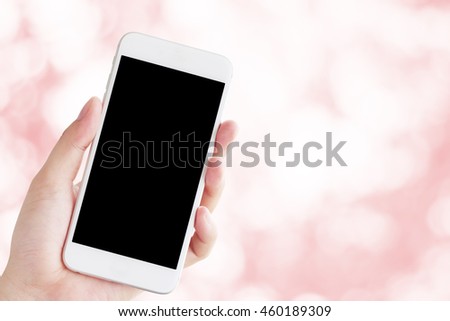 Hand holding smartphone, Abstract color bokeh background