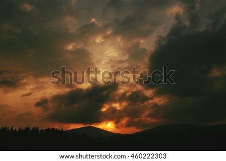 amazing sunset in mountains landscape, sun and clouds and woods in sunlight, tranquil moment of peace concept, space for text