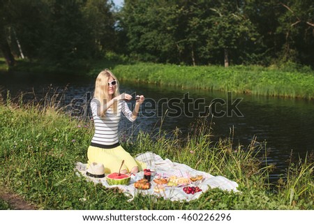 Girl photographing on phone picnic