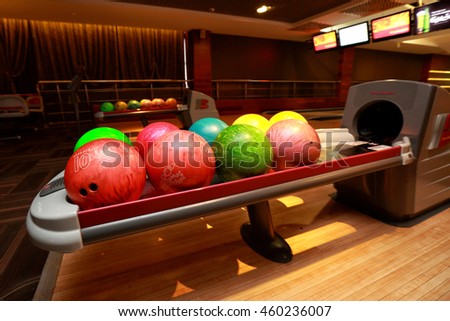 Colorful bowling balls on a rack.