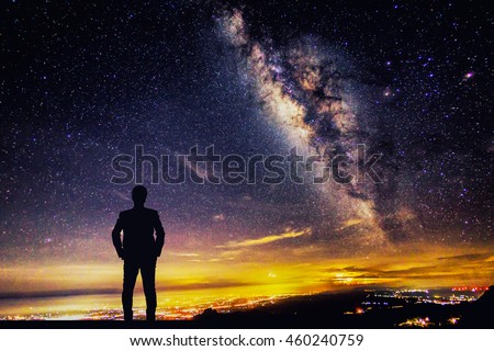 silhouette of man standing and looking to the Milky Way galaxy 