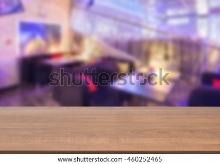 Dark wooden board empty table in front of blurred background. Perspective brown wood over blur in cafe interior - can be used for display or montage our products. Mockup your products