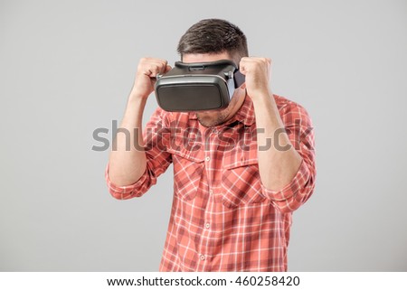 Man in fighter stand with virtual reality glasses isolated on a gray background