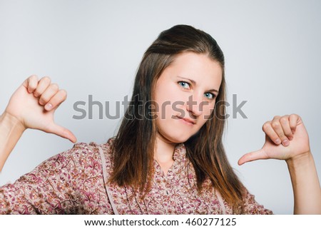 business woman pointing finger at themselves, studio photo isolated on a gray background