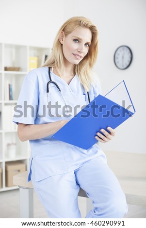Young female doctor and practitioner working at desk
