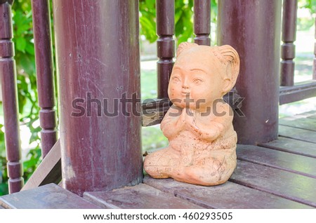 praying hand or " Sawatdee" hands sign or traditional of Thai greeting referred to as the "wai", child clay thailand on wooden floor