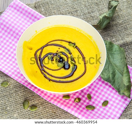 Pumpkin soup puree with spices on a wooden table. Rustic style. 