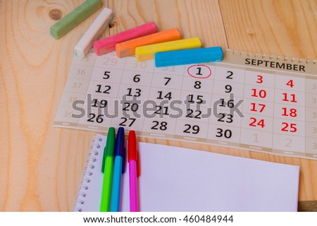 Back to school, calendar, colored chalk on wooden background. Royalty-Free Stock Photo #460484944