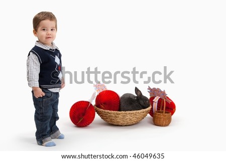Little boy with Easter bunny and decoration, looking at camera, isolated on white background.