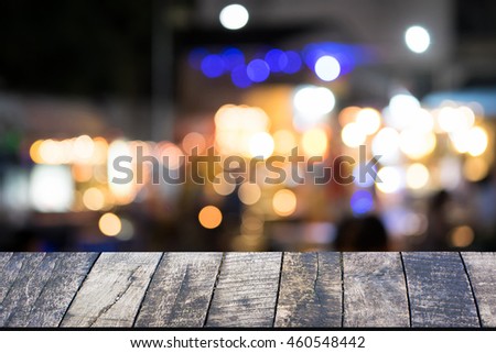 Empty wood table over bokeh at night restaurant for product display montage.