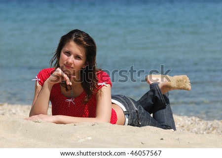 Beautiful young girl in sand at the beach on summer holiday vacation